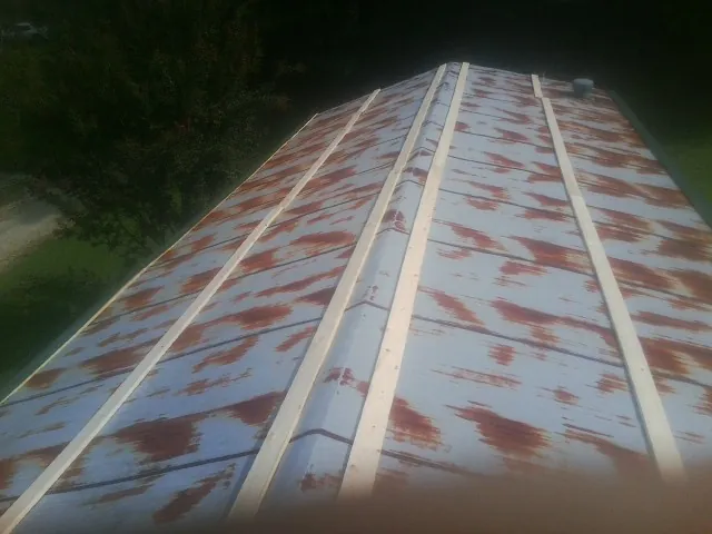 Rusted metal roof panels with new wood purlins before replacement — Storm Damage Roof Repair in Gordonsville by Roofing Brothers
