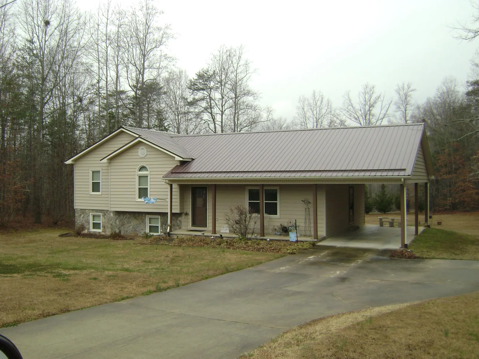 Brown metal roof on a tan split level home with an attached carport in Gordonsville